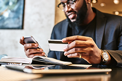 photo of a man conducting a credit card transaction on his smartphoe