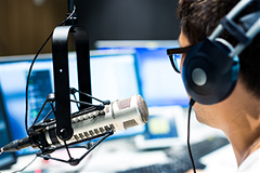 photo of a person wearing headphones speaking into a microphone