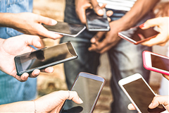 photo of multiple people looking at their smartphones