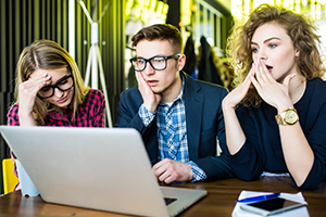 photo of 3 young adults reacting to online content