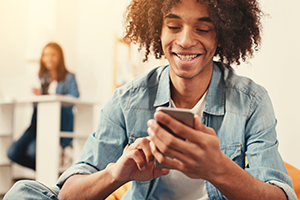 photo of a Gen-Z age African-American male using a smartphone