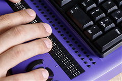 photo of a person using a Braille computer keyboard